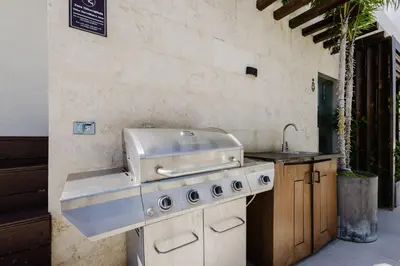 a kitchen with a grill and a sink at Luxury City Center Condo, Roof Top Jacuzzi in Santo Domingo