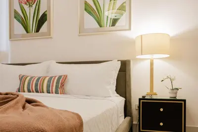 a bedroom with a bed with a lamp on a night stand at Luxury City Center Condo, Roof Top Jacuzzi in Santo Domingo