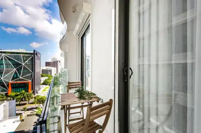 a balcony with a table and chairs and a view of a city at Luxury City Center Condo, Roof Top Jacuzzi in Santo Domingo