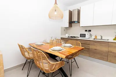 a kitchen with a wooden table and chairs at Elegant 1-BD Luxury Escape in Paradise in Estrella