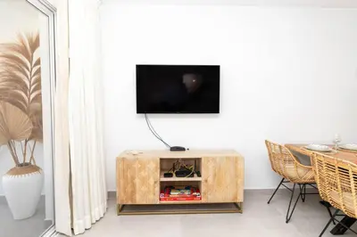 a living room with a tv on a white wall at Elegant 1-BD Luxury Escape in Paradise in Estrella