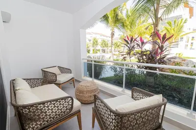 a room with chairs and a large window with palm trees at Elegant 1-BD Luxury Escape in Paradise in Estrella