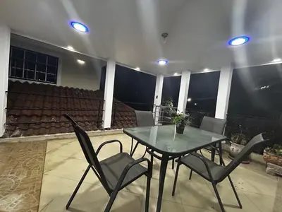 a table and chairs on a patio at night at Casa Villa para grupos grandes in Ciruelitos Arriba