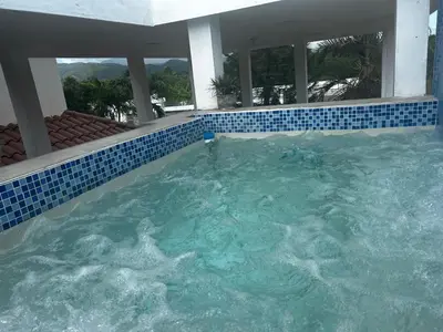 a large swimming pool with blue tiles in a house at Casa Villa para grupos grandes in Ciruelitos Arriba