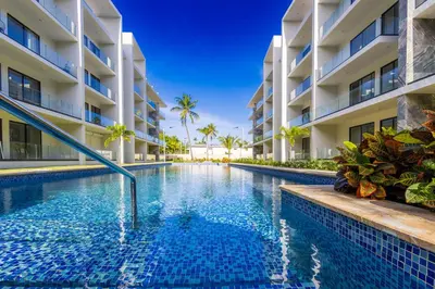 a swimming pool in front of a building at Stylish 1BR Apartment Near Bávaro Beach, Pool View in Punta Cana