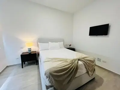 a bedroom with a bed and a tv on a wall at Cana Pearl in Punta Cana