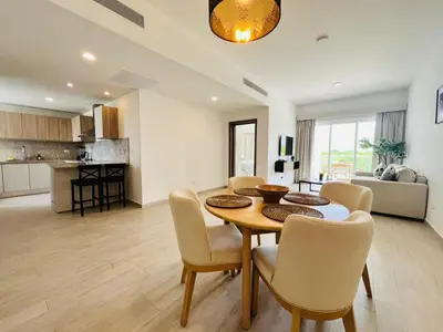 a dining room and living room with a table and chairs at Cana Pearl in Punta Cana
