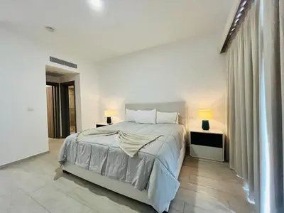 a white bedroom with a large bed and two lamps at Cana Pearl in Punta Cana