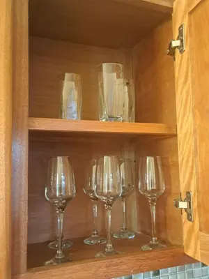 a row of wine glasses in a cabinet at Luxurious and comfortable in the safest area in Juan López