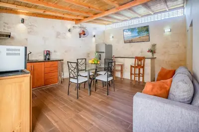 a kitchen and a living room with a table and chairs at Room in Sosua With Nice Jacuzzi in Sosúa