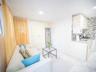 a white living room with a couch and a table at Studio In Sosua Center Strip Zone in Sosúa