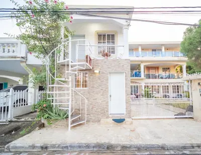 a brick house with a white door and a spiral staircase at Studio In Sosua Center Strip Zone in Sosúa