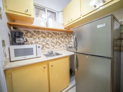 a small kitchen with a refrigerator and a sink at Studio in Sosua Center Near Sosua beach in Sosúa