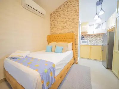 a small bedroom with a bed and a kitchen at Studio in Sosua Center Near Sosua beach in Sosúa