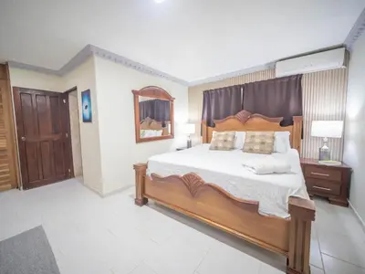 a bedroom with a large bed and a mirror at Spacious 1BR APT in Sosua strip in Sosúa