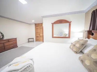 a large white bedroom with a bed and a mirror at Spacious 1BR APT in Sosua strip in Sosúa