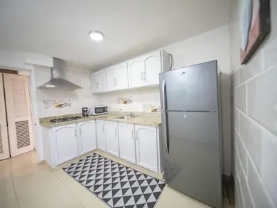 a kitchen with a refrigerator and a black and white tile floor at Cozy & Central 3BR Apt Secure & Comfortable in Sosúa