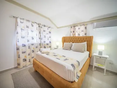 a bedroom with a bed with a wooden frame and curtains at Cozy & Quiet 1BT Apt Central in Sosua in Sosúa