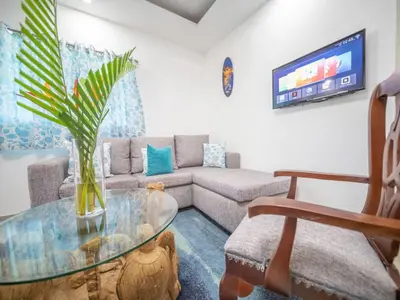 a living room with a couch and a glass table at Cozy & Quiet 1BT Apt Central in Sosua in Sosúa