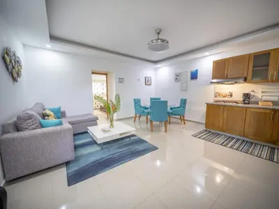 a living room with a couch and a table at Stylish 1BR Near Beach & Main Strip Sosua in Sosúa