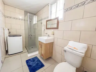a bathroom with a toilet and a sink and a shower at Secure and Central 2BR Apt in Sosúa