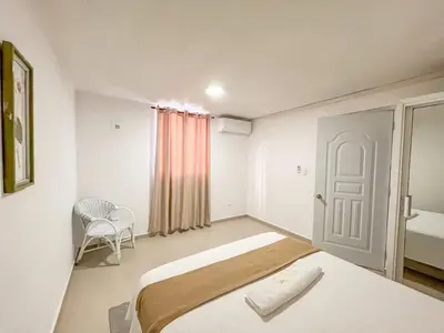 a bedroom with a bed and a chair in it at Secure and Central 2BR Apt in Sosúa