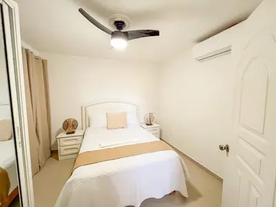 a bedroom with a bed with a ceiling fan at Secure and Central 2BR Apt in Sosúa