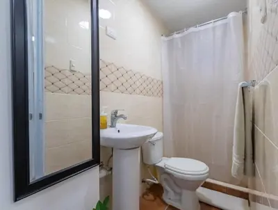 a bathroom with a toilet and a sink and a shower at Getaway room with shared Jacuzzi in the center in Sosúa