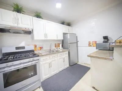 a kitchen with white cabinets and a stove and refrigerator at Affordable 1BR APT in Sosua Center - Strip Zone in Sosúa