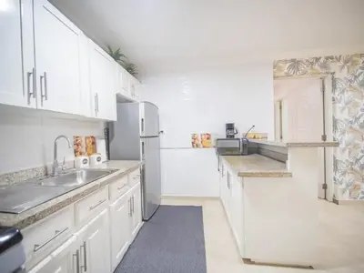 a white kitchen with a sink and a refrigerator at Affordable 1BR APT in Sosua Center - Strip Zone in Sosúa