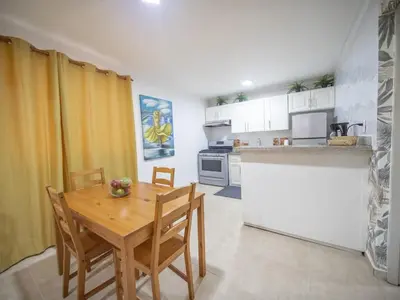 a small kitchen with a wooden table and chairs at Affordable 1BR APT in Sosua Center - Strip Zone in Sosúa