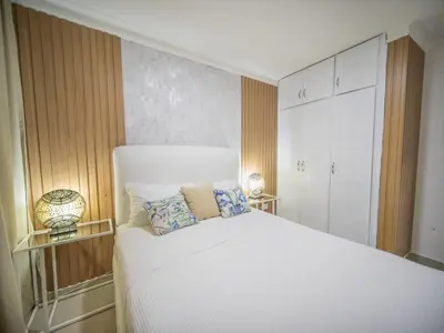 a bedroom with a large white bed with two pillows at 2BR APT in Sosua Center Strip zone in Sosúa