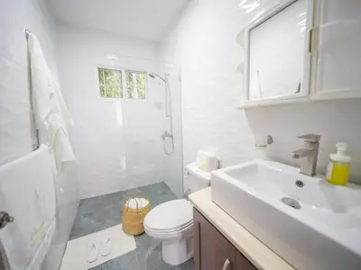 a white bathroom with a toilet and a sink at 2BR APT in Sosua Center Strip zone in Sosúa
