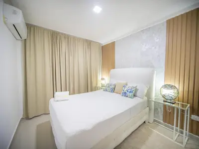 a bedroom with a white bed and a glass table at 2BR APT in Sosua Center Strip zone in Sosúa