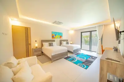 a living room with two beds and a couch at Luxury villa with Private beach access in Sosúa