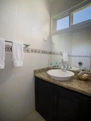 a white bathroom with a sink and a mirror at Garden Condos APT 35 - Affordable 1BR APT in Sosua in Sosúa