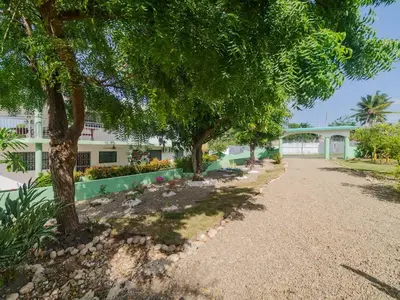 a walkway with trees in front of a building at COZY 7BR Villa BIG POOL Close to beach in Sosúa