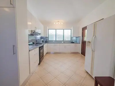 a large kitchen with white cabinets and appliances at COZY 7BR Villa BIG POOL Close to beach in Sosúa