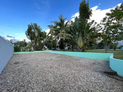 a gravel driveway with a blue wall and palm trees at COZY 7BR Villa BIG POOL Close to beach in Sosúa