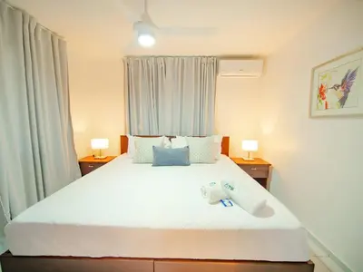 a bedroom with a large white bed with two lamps at COZY 7BR Villa BIG POOL Close to beach in Sosúa