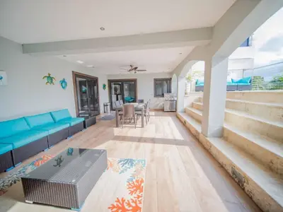 a living room with a blue couch and a table at 4BR Penthouse with Rooftop Pool in Sosua strip in Sosúa