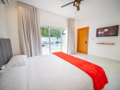 a bedroom with a white bed and a large window at First class 4BR KING SIZE Villa in Sosua town in Sosúa