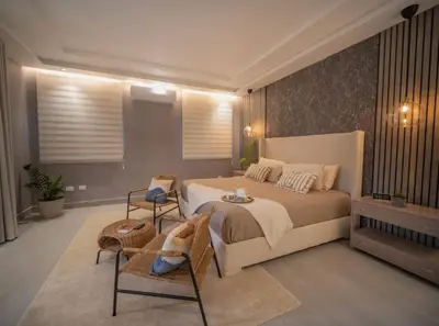 a bedroom with a large bed and two chairs at Stylish Luxury Villa in Sosua- 5BR Suites in Sosúa
