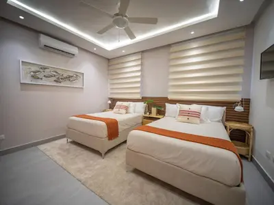 a bedroom with two beds and a ceiling fan at Stylish Luxury Villa in Sosua- 5BR Suites in Sosúa