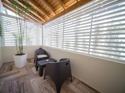 a room with a chair and a table and windows at North Coast Luxury Villa in Sosua - 6BR Suites in Sosúa