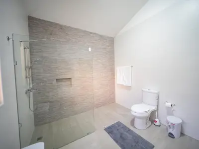 a bathroom with a toilet and a glass shower at Modern 5BR Private Villa in Sosua center in Sosúa