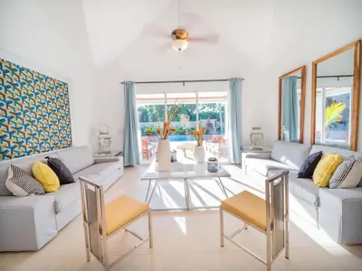 a living room with white furniture and a table at Sun and Soul Caribbean 9BR Villa in Sosua in Sosúa