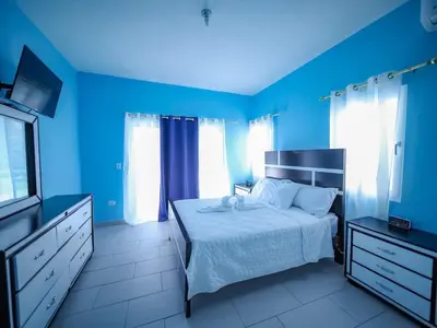 a blue bedroom with a bed and a television at 8BR Private Villa in Sosua 2 mins from Nightlife in Sosúa