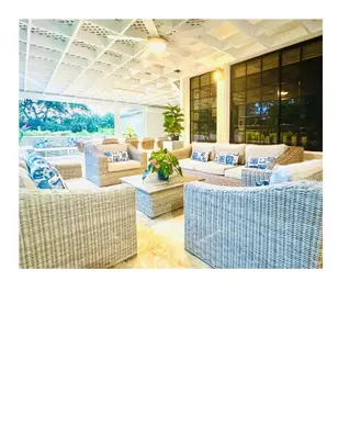 a living room with wicker chairs and couches at Casa De Campo Beautiful Villa with AC in the all house steps from the beach in La Romana