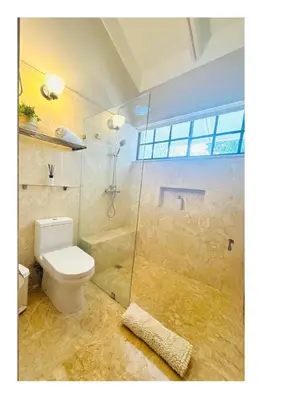 a bathroom with a toilet and a glass shower at Casa De Campo Beautiful Villa with AC in the all house steps from the beach in La Romana